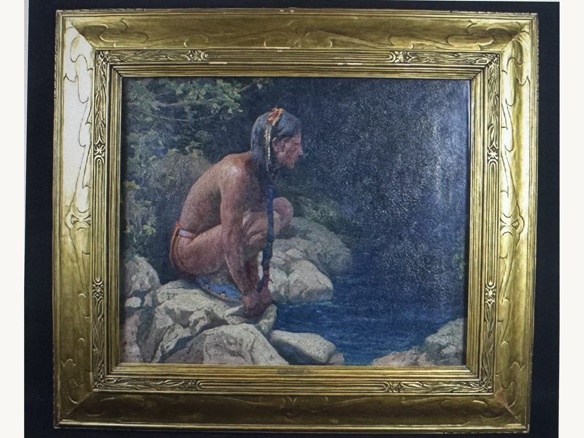 Oil painting by Eanger Irving Couse of a crouching figure by a mountain stream, in a gilt frame